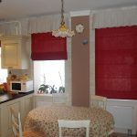 Cortinas rojas en cascada: un acento brillante en una cocina luminosa con tres ventanas