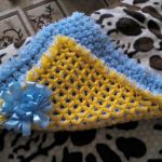 Insolite plaid jaune et bleu de pompons