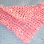 Plaid rose doux avec des pompons pour un nouveau-né