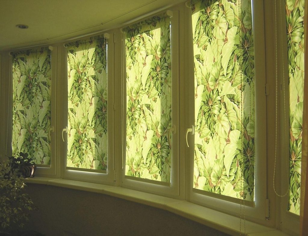 Tende arrotolate con motivi floreali sul balcone