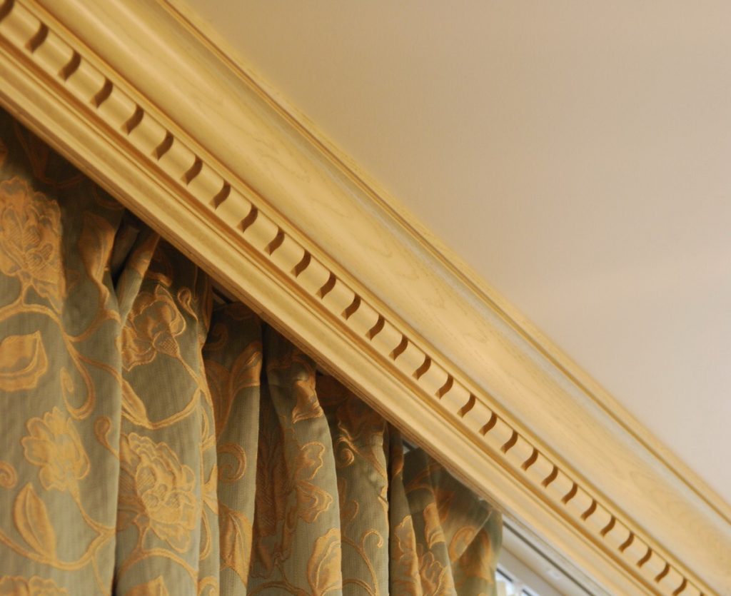 Curtain with an ornament on a wooden ceiling cornice