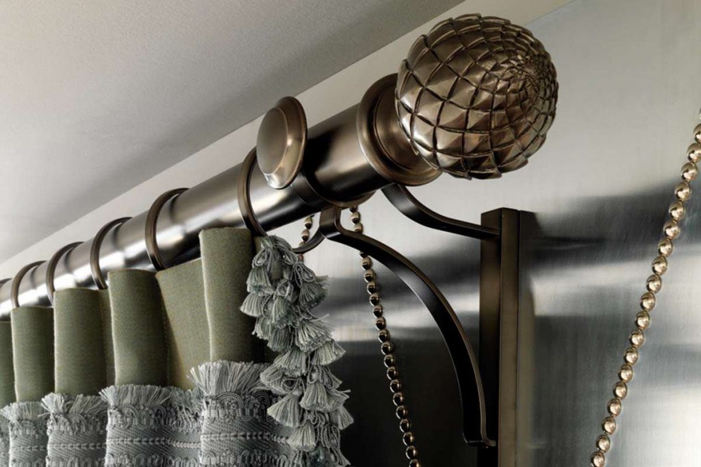 Curtain with a fringe on a round cornice with decorative elements