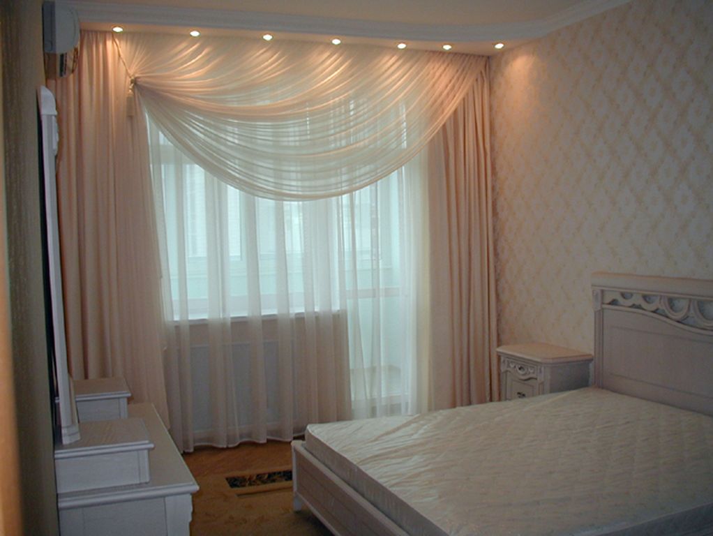 Tulle beige sur la fenêtre de la chambre à coucher dans la maison à panneaux