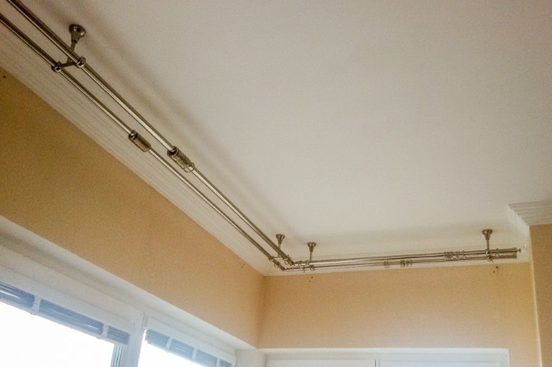 Double-row round cornice on the corner window in the living room