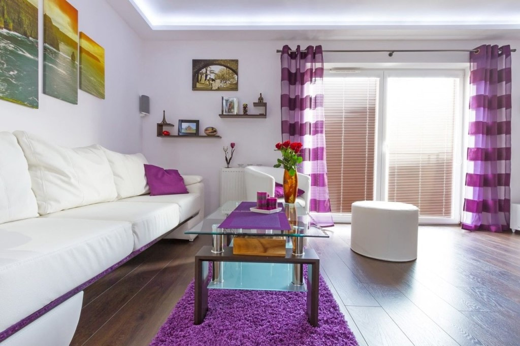 Cortinas con rayas moradas en la ventana del salón.