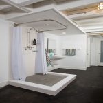 Two white curtains on the ledge in the bathroom