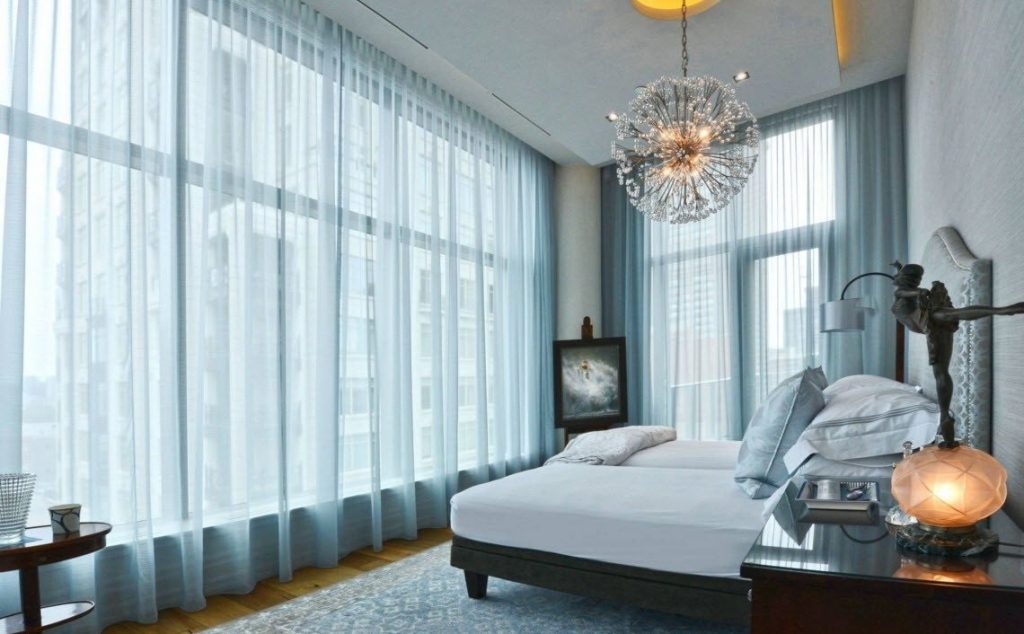 Décorer une fenêtre de chambre panoramique avec du tulle bleu