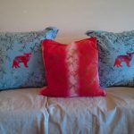 Oreillers bleus avec chatons rouges et un oreiller rouge au milieu
