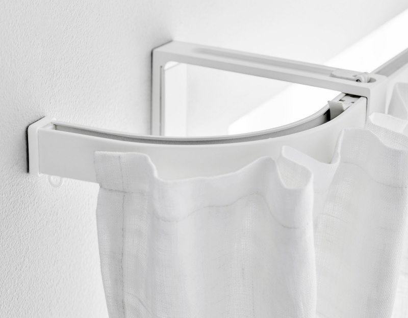 White curtain on an aluminum cornice with a bend
