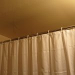 Beige curtain on a direct cornice in the shower