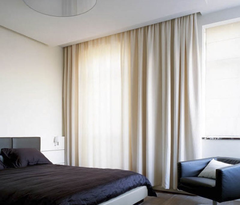 Cream curtain on an aluminum ledge in a niche