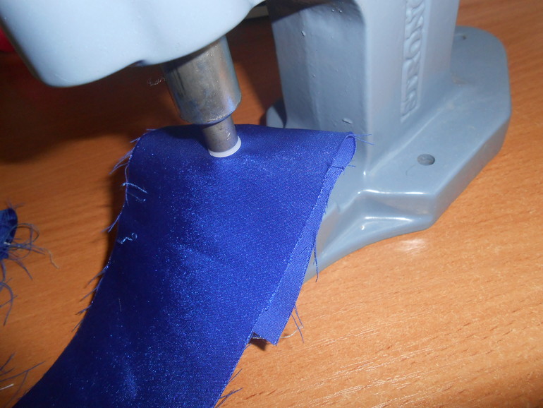 Flap of the grommet on the fabric using a hand press