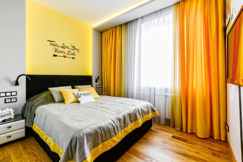 Cortinas naranjas en los aleros ocultos en el dormitorio.