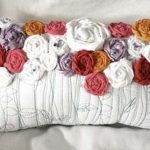 Oreiller original avec des roses à la main