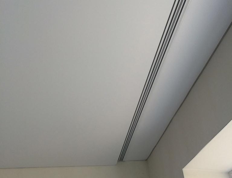 Perfil de plástico de la cornisa del techo en el nicho frente a la ventana.