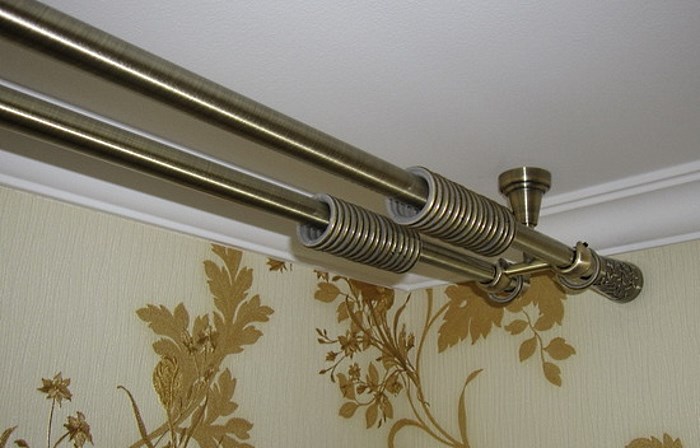 Metal cornice with fastening on the ceiling of the room