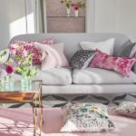 Des coussins multicolores rafraîchissent l'intérieur de la pièce grise