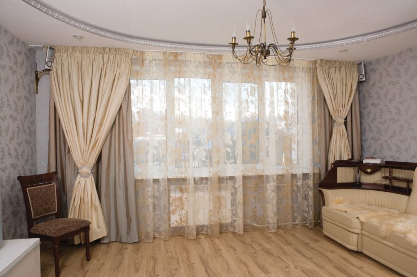 Bir panel evin salonunda farklı perdelerin bir arada kullanıldığı vitrin dekorasyonu