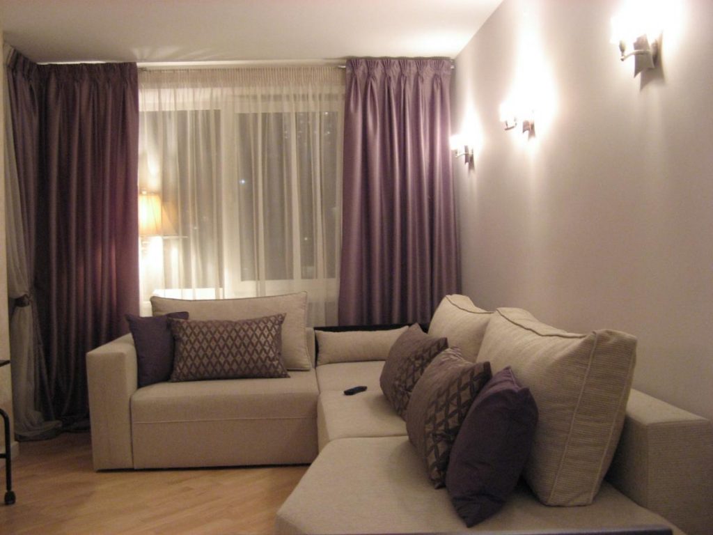 Luces de pared en el salón con cortinas moradas.