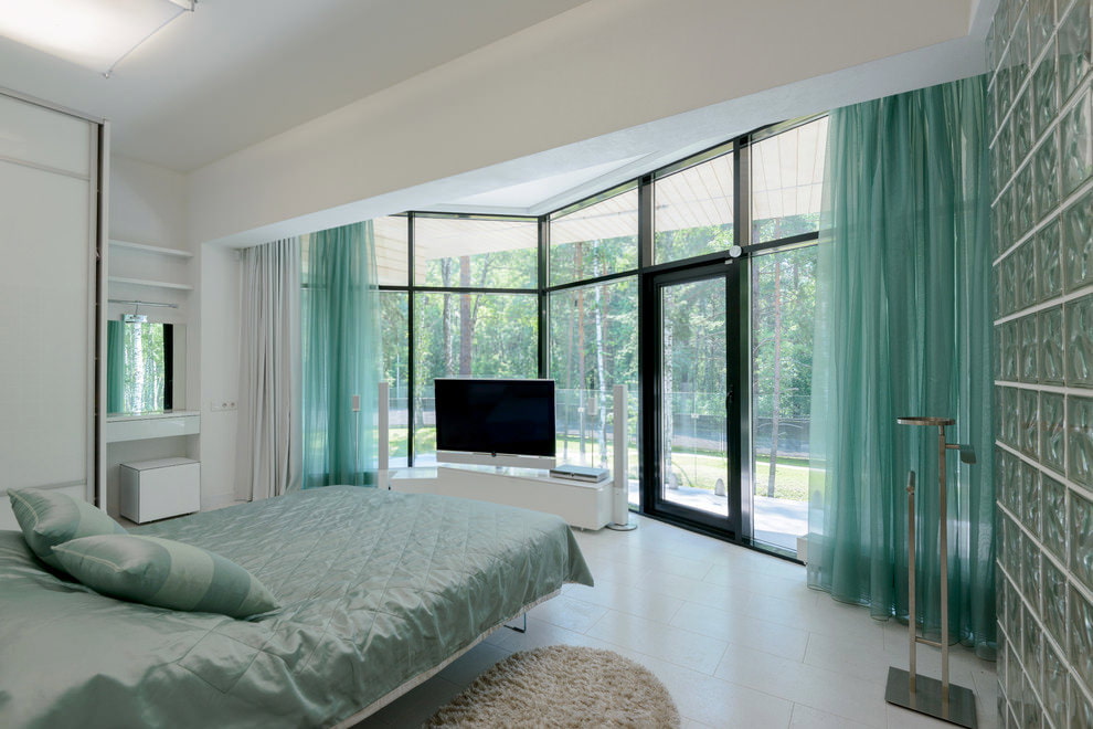 Intérieur d'une grande chambre avec des rideaux turquoises