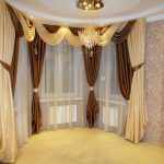 Curtains with lambrequin on the windows in the bay window