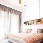 Chandelier with a fan over the bed in the bedroom
