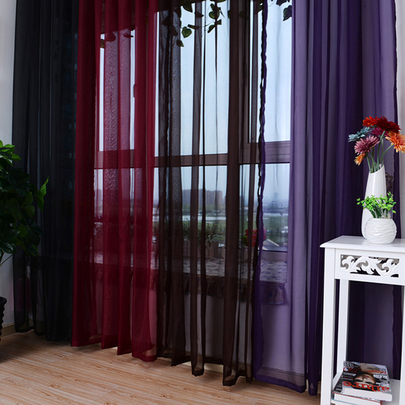 Tulle multicolore de couleurs sombres sur la fenêtre du salon