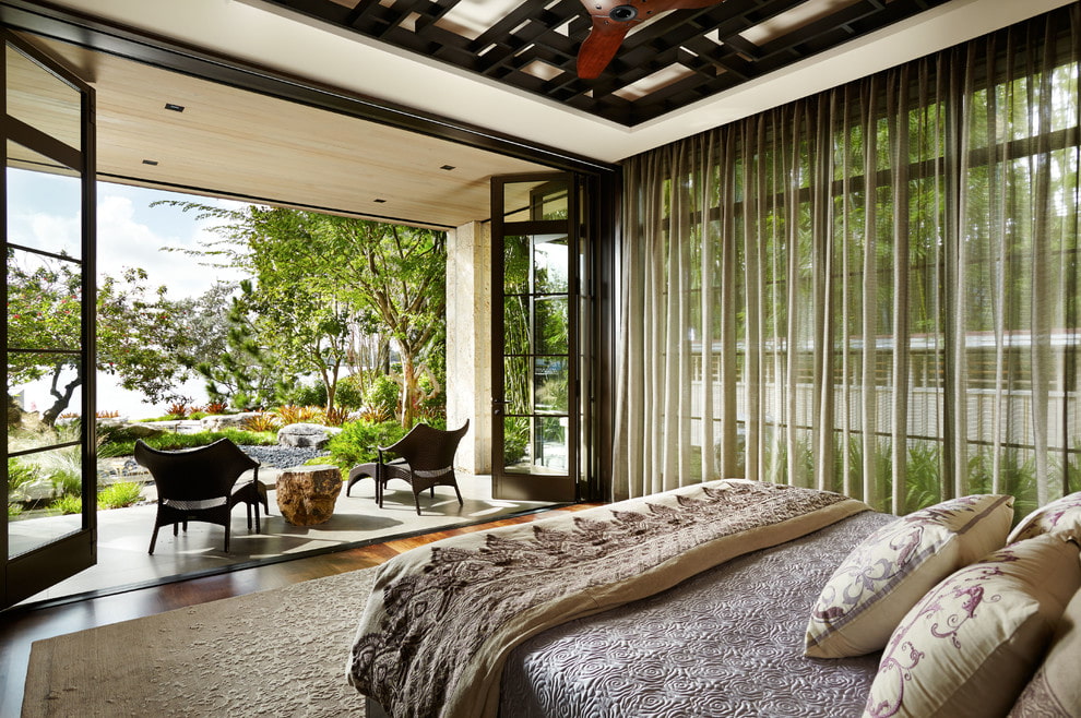 Intérieur de chambre à coucher avec fenêtres panoramiques dans une maison de campagne