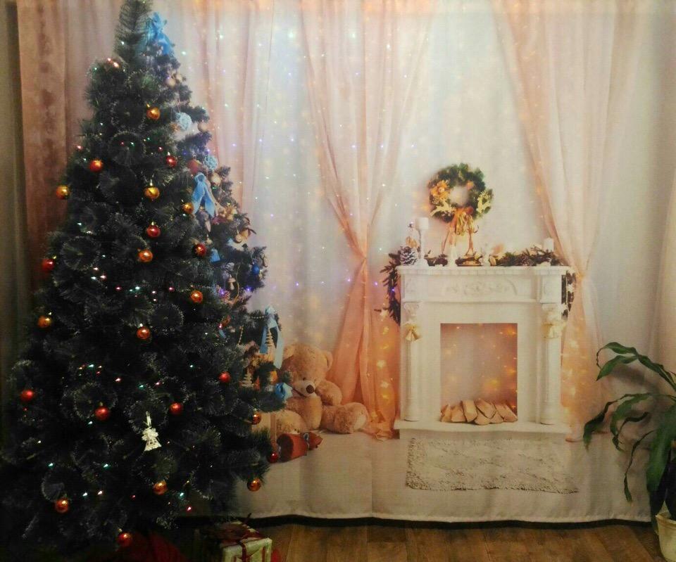 Albero di Natale sullo sfondo di tulle con un camino