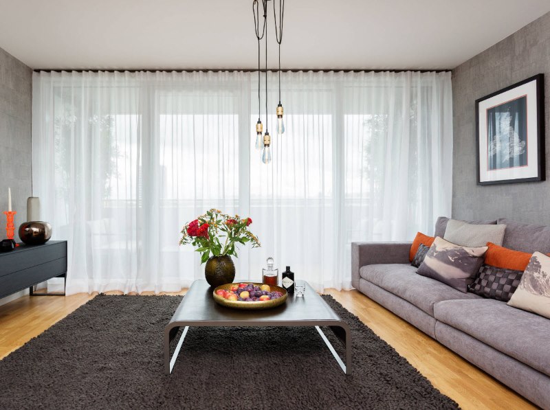 Drapage de la fenêtre panoramique en tulle dans le salon