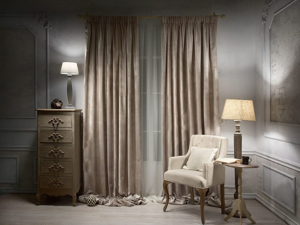 Commode étroite dans la chambre à coucher avec des rideaux de velours