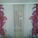 Tulle alla moda sulla finestra della sala nella casa del pannello