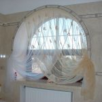 Arched window with curtains in the bathroom