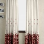 Weiße Vorhänge mit roten Klettblüten