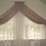 Two symmetrical windows with triangular inserts with tulle and lambrequin