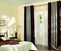Rideaux bicolores et tulle sur les anneaux de la chambre