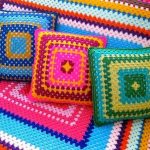 Plaid et oreillers sur le canapé des fils colorés en forme de carré