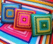 Plaid et oreillers sur le canapé des fils colorés en forme de carré