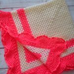 Plaid en crochet de couleur laiteuse à décor de corail