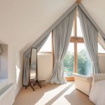 Gray floor curtains for a triangular window in the attic