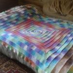Couvre-lit élégant sur le lit en technique de 10 boucles
