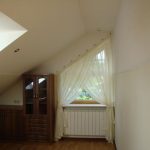 Curtains on the slanting eaves for a window under the roof