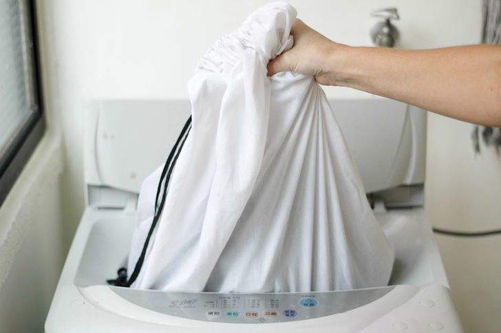 Loading the curtains in the machine in the bag for washing