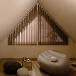 Triangular window with brown shutters for the rest room