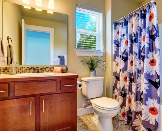 Grandes fleurs sur les rideaux de toile dans la salle de bain