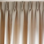 Arc plissé sur rideau beige