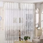 Rideaux blancs avec un ornement sur une porte