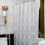 Rideau court avec monogrammes dans la salle de bain