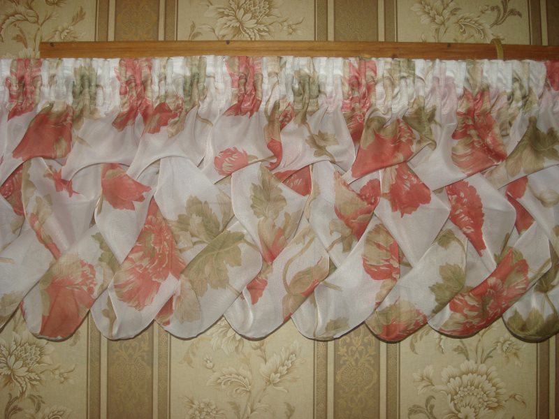 Puffs-pletenka sur lambrequin pour la fenêtre dans le salon