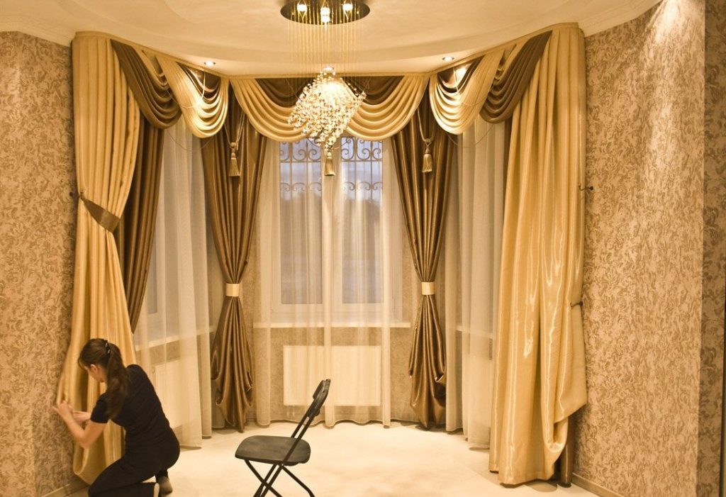 Beaux rideaux avec lambrequin sur les fenêtres de la baie vitrée dans le hall d'une maison privée